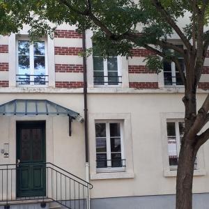 ein Gebäude mit einer grünen Tür und einem Baum in der Unterkunft Les Hauts de Marle in Marle-et-Behaine