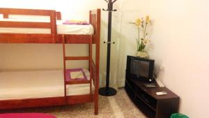 a bedroom with two bunk beds and a television at Cocoa Mews Cafe and Homestay in George Town