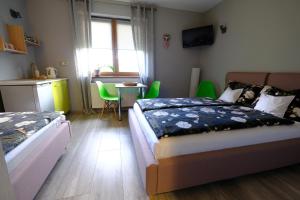 a bedroom with two beds and a kitchen with a table at Noclegi Wiejski Raj in Chocieszow