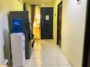 a hallway of a room with a refrigerator and a door at Aloha Guest House 2 - Female Only in Tangerang