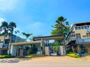 a building with palm trees in front of a street at Aloha Guest House 2 - Female Only in Tangerang