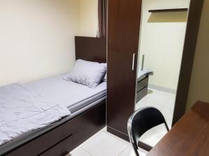 a small bedroom with a bed and a chair at Aloha Guest House 2 - Female Only in Tangerang