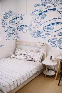 a bedroom with a bed with blue fishes on the wall at Moon walks slowly in Tainan +188 photos