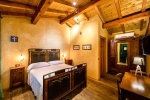 a bedroom with a bed and a desk and a television at Cantina Anzivino - Affittacamere in Gattinara