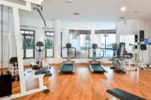 a gym with treadmills and elliptical machines at Hotel Resort & Spa Baia Caddinas in Golfo Aranci