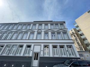 a white building with white windows on a street at FeWo Jade in Wilhelmshaven