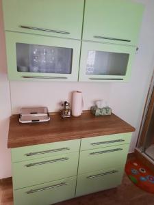 cocina con armarios verdes y encimera en České Švýcarsko - Apartmán pro 2-3 dospělé osoby, en Srbská Kamenice