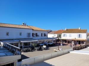 a view of a town with buildings and a boardwalk at Le Cocardier in Saintes-Maries-de-la-Mer