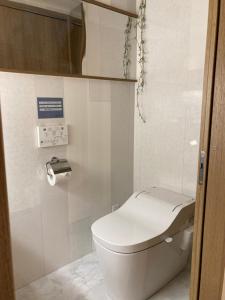 a bathroom with a white toilet in a stall at HOJO MACHI HOSTEL in Kasai