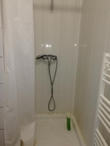 una doccia con tubo in un bagno bianco di LOUE MAISON ENTIÈRE PROPRE, Endroit calme, à 5 minutes gare mantes la jolie a Mantes-la-Jolie