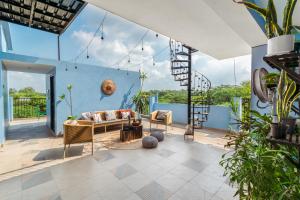 a living room with a couch and some plants at Minimalist Poshtel & Suites in New Delhi