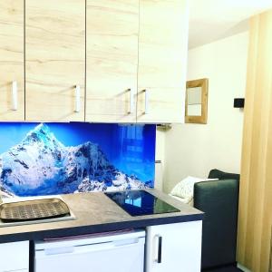 a kitchen with a desk with a laptop on a counter at L'AnsloBoys Montagne L2 in Les Deux Alpes