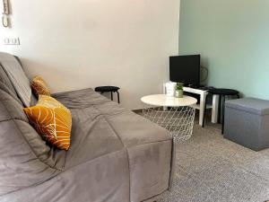 uma sala de estar com um sofá e uma mesa em L'appartement d'houyet - Esc'Appart em Houyet