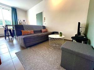 uma sala de estar com um sofá e uma mesa em L'appartement d'houyet - Esc'Appart em Houyet