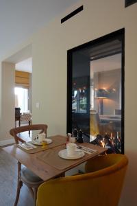 a dining room table with two chairs and a fireplace at Les Terrasses des Falizes B&B in Rochefort