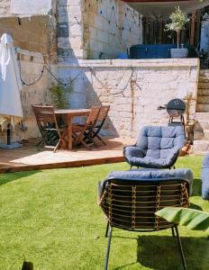 eine Terrasse mit zwei Stühlen und einem Tisch im Gras in der Unterkunft La Suite Angoulême in Angoulême