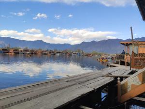 a dock on a body of water with boats at Young Shahzada Group of Houseboats in Srinagar