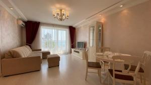 a living room with a table and a dining room at SeaView 1BR balcony Apartment in Sochi