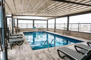 a large swimming pool with chairs in a building at Noor Land Hotel in Baghdad