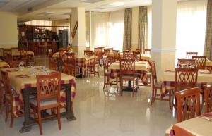une salle à manger avec des tables et des chaises dans un restaurant dans l'établissement Hotel Il Chierichetto, à San Giovanni Rotondo