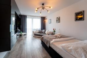 a bedroom with a large bed and a couch at Apartament Nero in Mielec