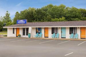 a building with blue chairs in a parking lot at Dover Inn and Suites in Dover