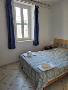 a bedroom with a bed and a window at Le Cocardier in Saintes-Maries-de-la-Mer