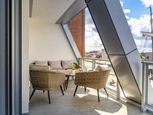 einen Balkon mit Korbstühlen und einem Tisch in der Unterkunft Hafenspitze App. 23 in Wismar