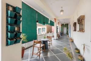 a room with a table and chairs and a green wall at Haveli Kalwara - A Heritage Hotel in Jaipur