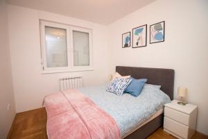 een slaapkamer met een bed en een raam bij M&A apartment in Lukavica