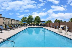 a swimming pool with chairs and a building at La Quinta by Wyndham Joplin in Joplin