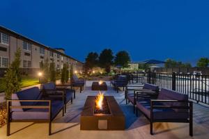 a patio with couches and a fire pit in front of a building at La Quinta by Wyndham Joplin in Joplin