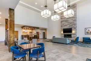 a lobby with a table and chairs and a fireplace at Comfort Suites North Tupelo in Tupelo