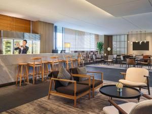 a hotel lobby with a bar and tables and chairs at Novotel Shanghai Qingpu Excellence in Shanghai