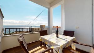 a table and chairs on a balcony with a view of the ocean at Villa Ivanišević in Omiš