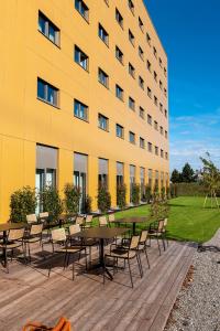 un edificio giallo con tavoli e sedie di fronte di FIRMAMENT Hotel a Feldkirch