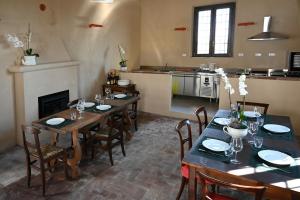 uma sala de jantar com mesas e cadeiras e uma cozinha em Tenuta Favorita Country House B&B em Fontanetto da Po