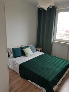 ルブリンにある5 min od Dworca PKP Apartamentのベッドルーム1室(緑のシーツが敷かれたベッド1台、窓付)