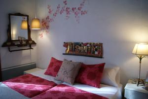 1 dormitorio con cama con almohadas rosas y espejo en Peregrinando, pensión con encanto en Navarrete