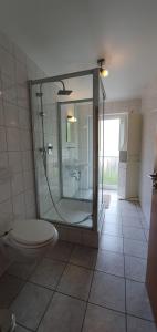 a bathroom with a glass shower and a toilet at Outletcity Ferienwohnung Wohnung 1 in Metzingen