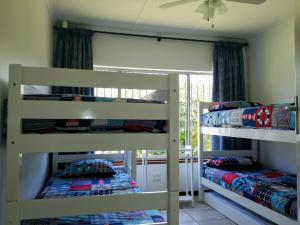 two bunk beds in a room with a window at Zinkwazi Beach townhouse in Zinkwazi Beach