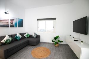 ein Wohnzimmer mit einem Sofa und einem Flachbild-TV in der Unterkunft Casa Salazar in Fuencaliente de la Palma