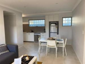 a living room and kitchen with a table and chairs at MODERN CLOSE AIRPORT/SHOPS FREE NETFLIX WINE WIFI in Perth
