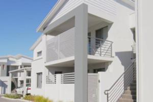 a white apartment building with stairs in front of it at MODERN CLOSE AIRPORT/SHOPS FREE NETFLIX WINE WIFI in Perth