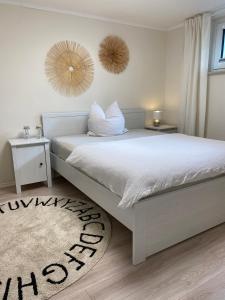 a bedroom with a white bed and a rug at Stylische Wohnung in ruhiger Lage, sehr messenah in Laatzen