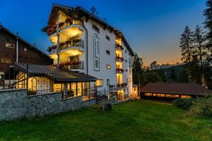 a large building with a yard in front of it at Pensiunea Hilltop in Predeal