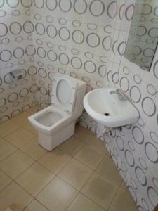 a bathroom with a toilet and a sink at Dich Comfort Hotel University Branch in Gulu