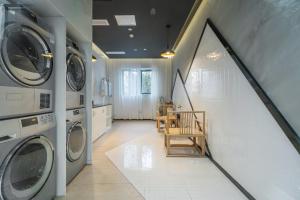 a laundry room with washing machines and a table and chairs at Atour X Chongqing Jiefangbei pedestrian Street in Chongqing