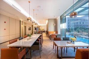 a restaurant with tables and chairs and large windows at Atour Hotel Wuhan Jinyin Lake in Wuhan