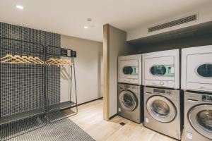 a laundry room with three washers and three dryers at Atour Light Nanjing Xinjiekou NetEase CloudMusic in Nanjing
